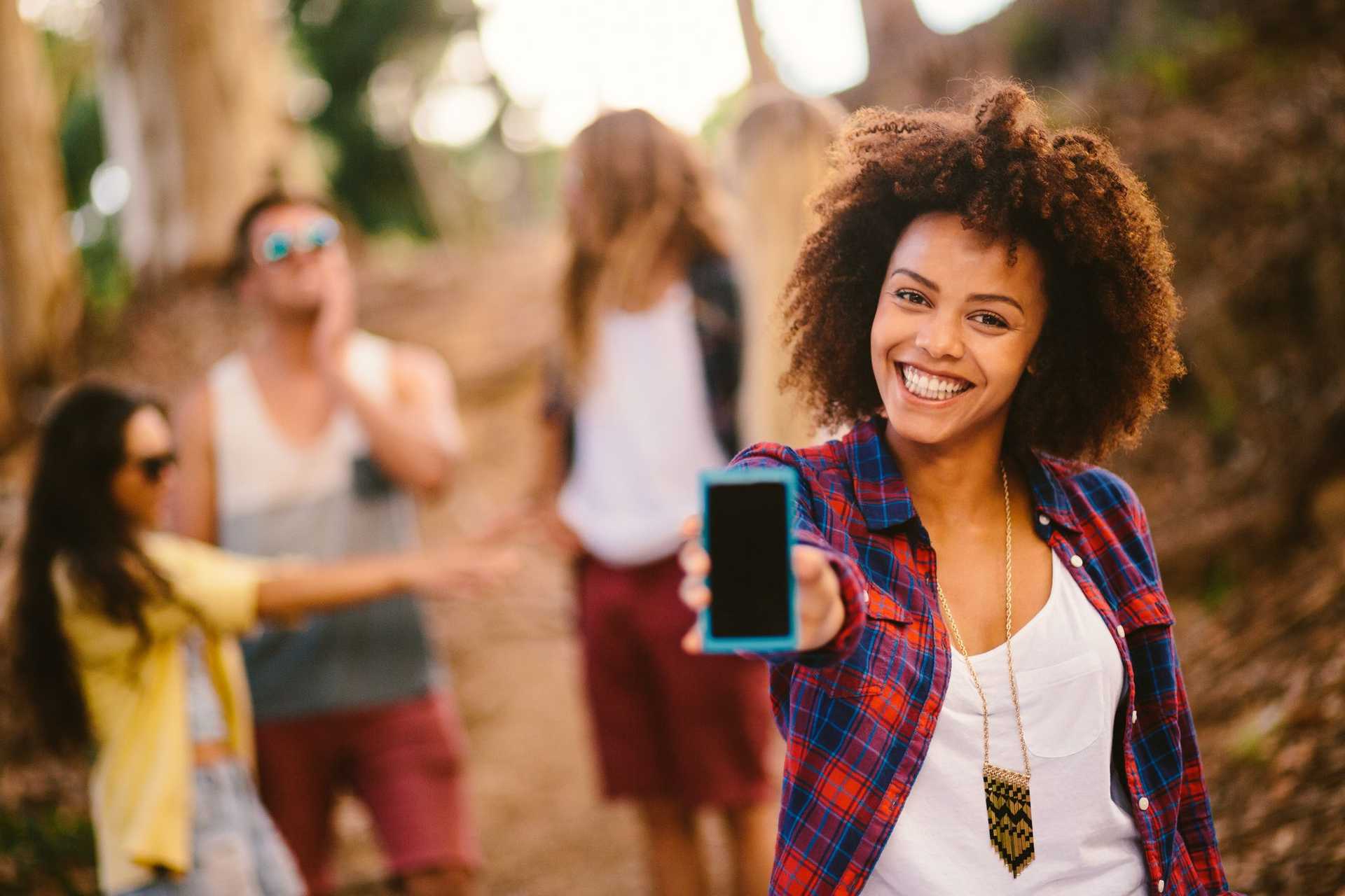 Woman smiling holding up her phone